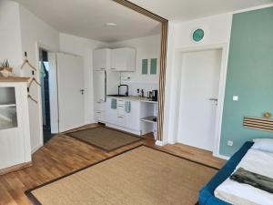 a room with a bed and a kitchen with a mirror at Fewo Schwäbische Eisenbahn in Meckenbeuren