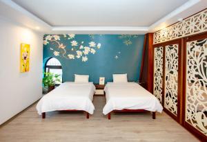 een kamer met drie bedden en een blauwe muur bij Song Anh Hotel Tuần Châu in Ha Long +136 foto's