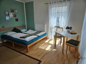 a bedroom with a bed and a desk and a table at Fewo Schwäbische Eisenbahn in Meckenbeuren