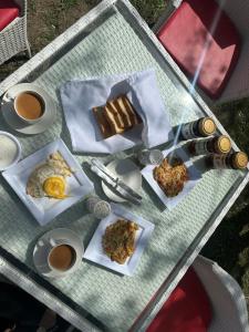 a table with plates of food and cups of coffee at MONTAGNA PODS,Best resort in skardu , Best Guest house In skardu in Skardu