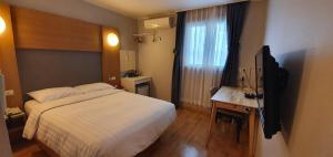 a hotel room with a bed and a television at Appletree Hotel Pohang in Pohang