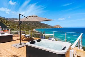 ein Whirlpool auf einer Terrasse mit Sonnenschirm in der Unterkunft Emerald Hotel Residence Cefalù in Cefalú