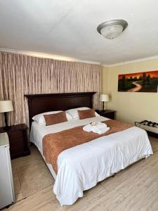 a bedroom with a large bed with white sheets at Limpopo Guest Manor in Polokwane