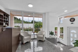 a living room with two chairs and a table and windows at Apartments Villa Katarina in Tučepi