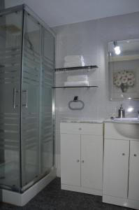 La salle de bains est pourvue d'une douche en verre et d'un lavabo. dans l'établissement Apartamento Boutique Hirta, à Peñíscola