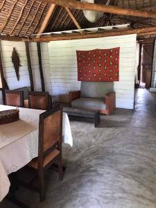 a room with a table and chairs and a couch at Beach front Cottage in Mahambo