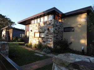 Casa con un edificio de piedra con ventana en Cabañas Klippen en Mar del Plata