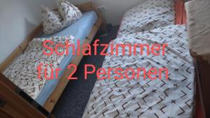 ein Schlafzimmer mit zwei Betten mit dem Wort Quarantäne für Passagiere in der Unterkunft Ferienwohnung Hentzschel in Brand-Erbisdorf