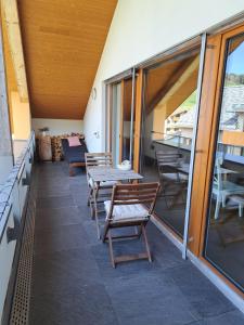 a patio with chairs and tables on a building at Chalet-Stil privat Zimmer 1-4 in Engelberg