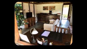 a living room with a table and a couch at Beach front Cottage in Marofarihy