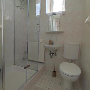 uma casa de banho com um WC, um chuveiro e um lavatório. em Villa Vanília em Keszthely