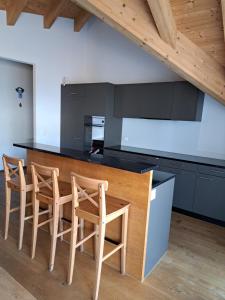 cocina con encimera de madera y sillas en Chalet-Stil privat Zimmer 1-4 en Engelberg
