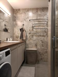 a bathroom with a sink and a washing machine at Apartamentai Šviesa 2 in Palanga