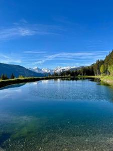 um lago com montanhas cobertas de neve no fundo em Angererhof em Jochberg