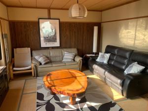 ein Wohnzimmer mit einem Sofa und einem Tisch in der Unterkunft Hakuba Ski Condos in Hakuba