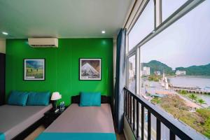 une chambre verte avec un canapé et une fenêtre dans l'établissement Casa Bonita Hotel, à Cat Ba