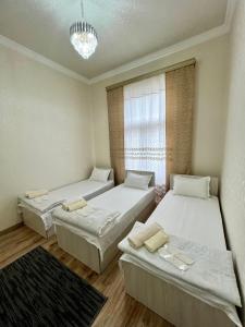 um quarto com duas camas e uma janela em MrShox Hostel em Samarkand
