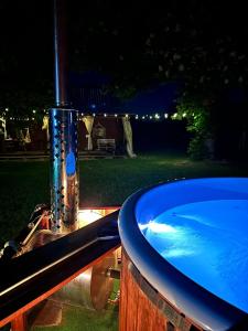 una bañera con una fuente en un patio por la noche en Poleskie zacisze, domek na wyłączność, Wi - fi, Domek Bocian 
