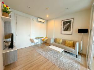 a living room with a couch and a table at The Base Condominium Behind Central Festival Phuket By T in Ban Rangeng