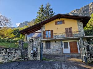 una casa de piedra con un balcón en un lateral. en Casa di montagna en Aisone
