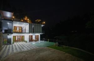 ein großes weißes Haus in der Nacht mit Hof in der Unterkunft Wenasa Holiday Resort in Diyatalawa