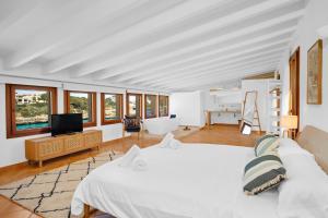 a bedroom with a white bed and a television at LA CITA DEL MAR Cala Marsal Luxury SEA experience in Portocolom +45 photos