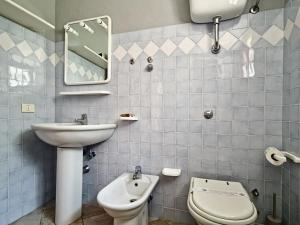 a bathroom with a sink and a toilet and a mirror at Dommos - Casa Sicutera in Orosei