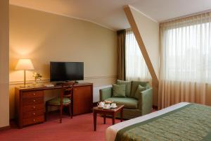 a hotel room with a bed and a chair and a television at Hotel Barchetta Excelsior in Como