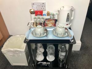 Norman Guest House with Free Parking في ويتبي: طاولة مع آلة صنع القهوة وغلاية الشاي