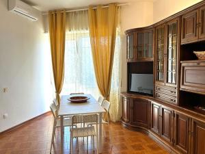 a dining room with a table and a television at Appartamento TD in Follonica