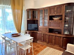 a living room with a table and a large entertainment center at Appartamento TD in Follonica +21 photos
