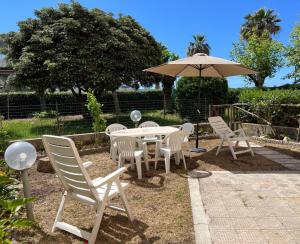 a table and chairs and an umbrella in a yard at Appartamento TD in Follonica
