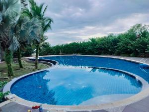 a large blue swimming pool with trees in the background at Idea Homestay 3 in Chemor