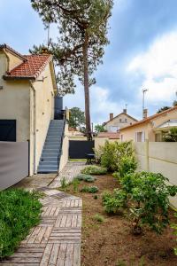 ein Hinterhof mit einer Treppe und einem Haus mit einem Zaun in der Unterkunft Villa de la plage in Saint-Brevin-les-Pins