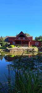 a large building with a pond in front of it at Cottage - Liepų Sodyba in Joniškėlis