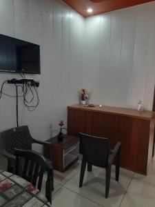 a room with a tv and a table and chairs at Ganpati Villa in Dehradun +1 photo