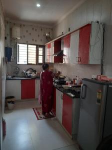 a woman standing in a kitchen preparing food at Ganpati Villa in Dehradun