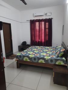 a bedroom with a bed with a comforter and a window at Ganpati Villa in Dehradun