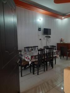a dining room with a table and chairs and a television at Ganpati Villa in Dehradun
