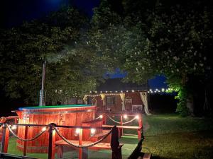 un escenario de madera con luces en el patio por la noche en Poleskie zacisze, domek na wyłączność , Wi - fi, Domek Czapla, 