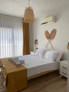 - une chambre avec un grand lit blanc et un ventilateur mural dans l'établissement Aden Apart Otel, à Fethiye