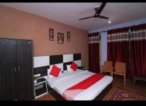 1 dormitorio con 1 cama grande con almohadas rojas en Mcleodganj Diaries Homestay, en Dharamshala