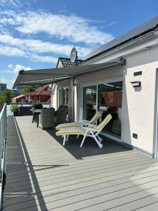 a deck with two chairs and a table at Penthouse Jever - großzügige Dachterrasse in Jever