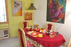 a table with a red table cloth and a portrait of a woman at Nina Kochhar's Homestay in New Delhi +6 photos