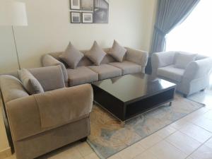ein Wohnzimmer mit einem Sofa und einem Couchtisch in der Unterkunft Kuwait Residence in Kuwait