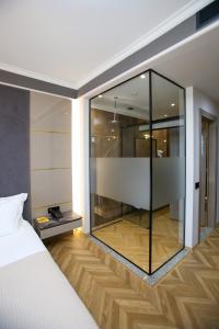 1 dormitorio con ducha acristalada y 1 cama en Belvedere Hotel en Vlorë