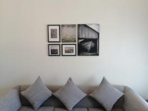 a living room with a couch with four pictures on the wall at Kuwait Residence in Kuwait