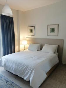 ein Schlafzimmer mit einem großen weißen Bett mit zwei Kissen in der Unterkunft Kuwait Residence in Kuwait