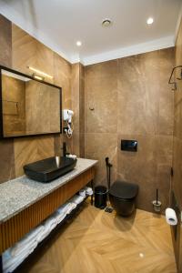 a bathroom with a black sink and a toilet at Belvedere Hotel in Vlorë