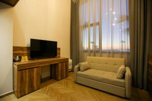 a living room with a couch and a flat screen tv at Belvedere Hotel in Vlorë